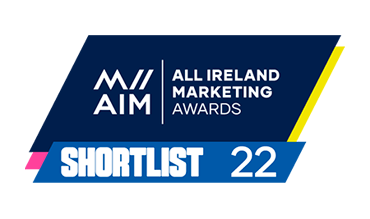 Large tilted blue rectangle with a yellow and pink streak on the sides and the text All Ireland Marketing Awards with a smaller rectangle on top with the text Shortlist 2022 logo