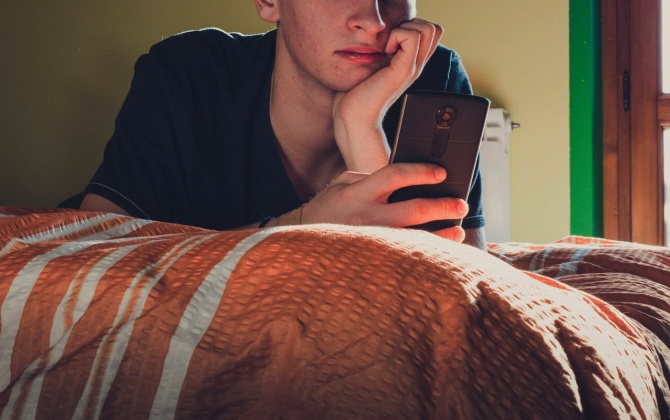 Teenager using phone in bedroom header with overlay